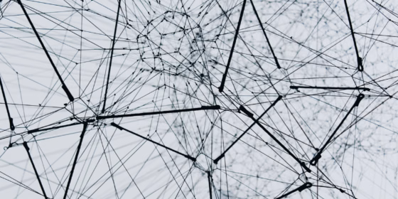 Abstract network graphic of interconnected black lines, and nodes creating a 3D geometric web on a light background.